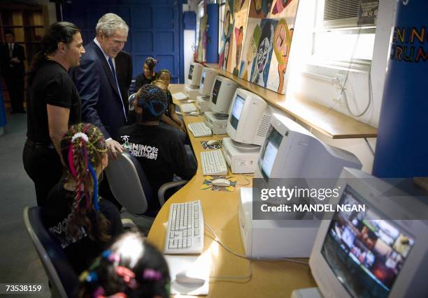 President George W. Bush and musician Flavio Pimenta , founder of "Meninos do Murumbi", chat with children in the computer lab during a visit to...