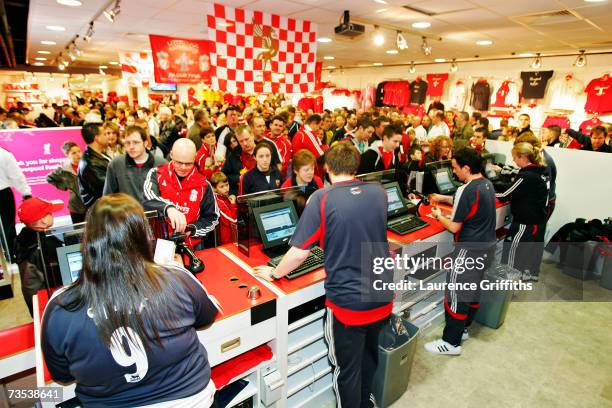 Cashiers serve fans in the club shop before the Barclays Premiership match between Liverpool and Sheffield United at Anfield on February 24, 2007 in...