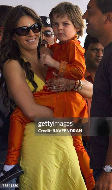British actress Elizabeth Hurley carries her son Damian as they arrive at Jodhpur Airport, 10 March 2007, before boarding an aeroplane for Mumbai....