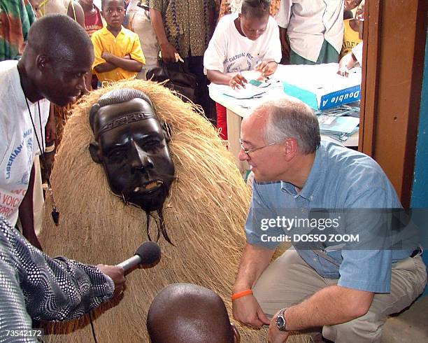 Ambassador to Liberia Donald Boots in conversation with a mask dancer 09 March 2007 in Ganta, north of Liberia, where a peace and reconciliation...