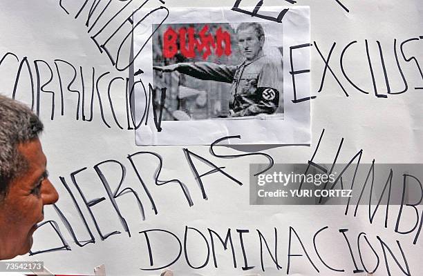 Man looks at a banner with slogans against US President George W. Bush Latin American's tour during a protest 10 March 2007 in San Salvador. Bush...