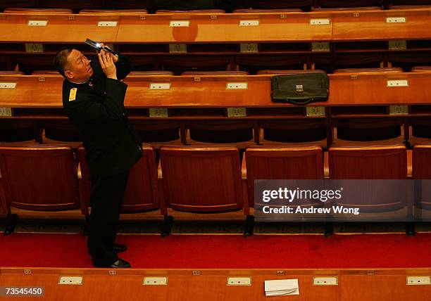 Military delegate takes pictures at the Great Hall of the People before the third plenary session of the National People's Congress, or parliament,...