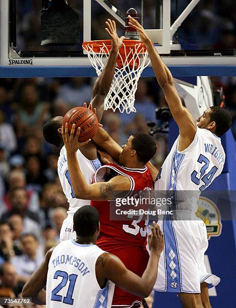Brandon Costner of the North Carolina State Wolfpack is stopped by Marcus Ginyard and Brandan Wright of the North Carolina Tar Heels in the ACC Men's...