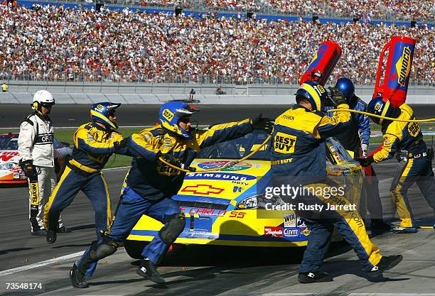 Crew members for Jeff Green, driver of the Samsung Four Seasons of Hope Chevrolet, work on the car during a pit stop, during the NASCAR Nextel Cup...