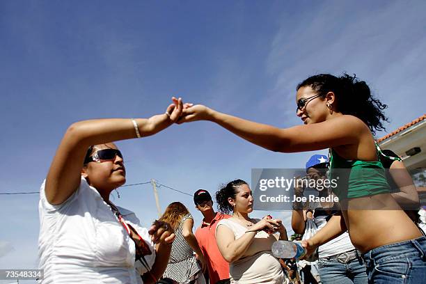 People dance to the tune of the salsa music playing as they attend the annual Calle Ocho celebration March 11, 2007 in Miami, Florida. The event is...