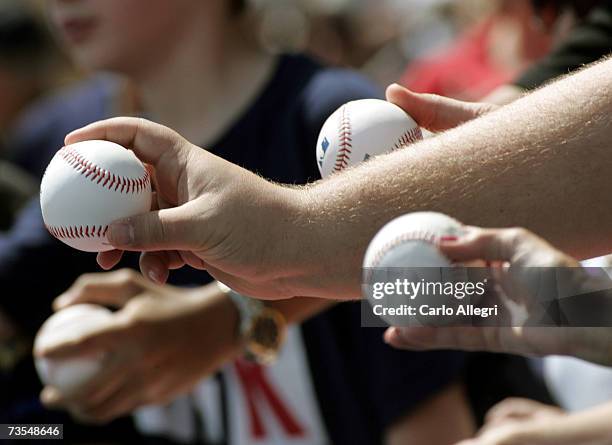 Fans hold out balls hoping to get them signed at the Boston Red Sox Spring Tranining game against the Baltimore Orioles on March 11, 2007 at City Of...