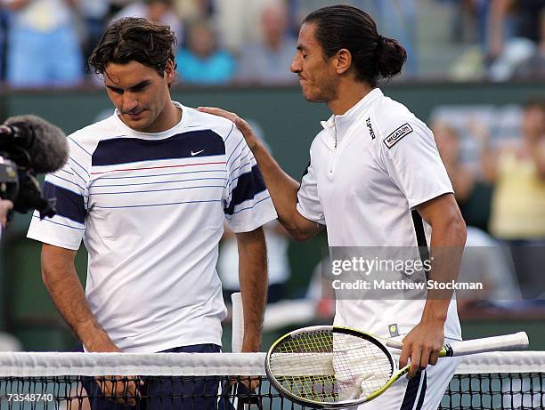 Guillermo Canas of Argentina puts his arm on the shoulder of Roger Federer of Switzerland after their match at the Pacific Life Open on March 11,...