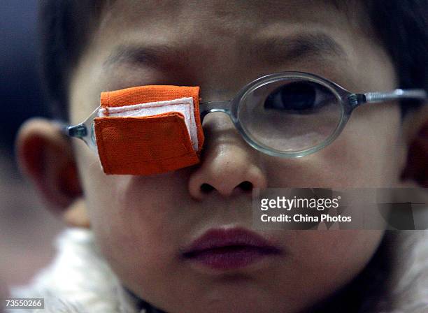 Child from a migrant worker family who suffers from an eye disease attends the Lingzhi Primary School, a private migrant school atop a farmer's...