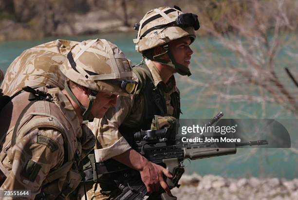 British Royal Marines wait as a helicopter arrives to deliver fresh Afghan and UK forces to Kajaki on March 12, 2007 in Southern Helmand province,...