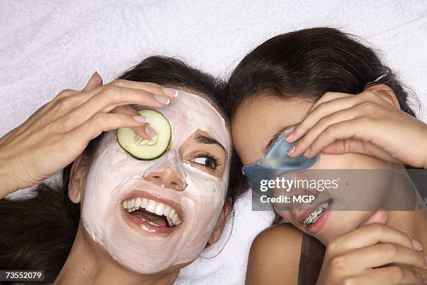 mother and daughter (10-12) wearing beauty masks, close-up - cucumber eye mask stock pictures, royalty-free photos & images