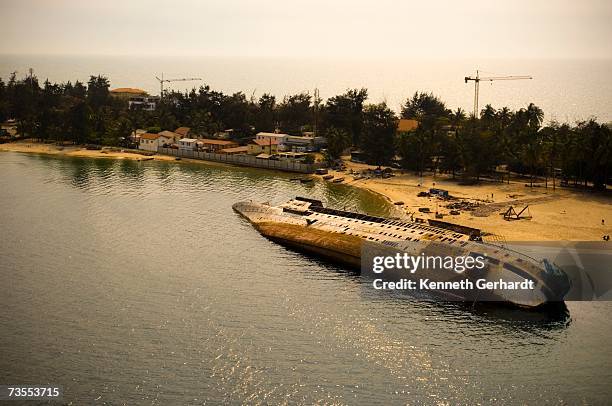 a view of the bay with and old shipwreck on its side - civil war angola stock pictures, royalty-free photos & images