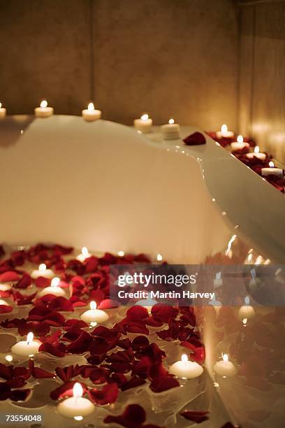 romantic scene of candles and rose petals in bath - red tub stock pictures, royalty-free photos & images