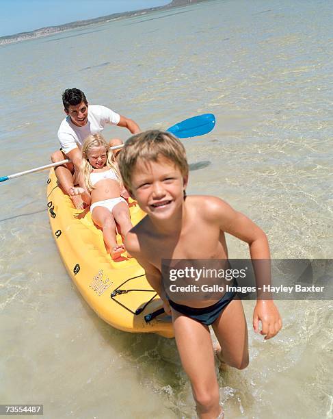 father with his children in a canoe in the sea - speedo boy stock pictures, royalty-free photos & images