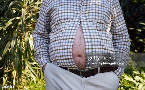 man with his large belly bursting through his shirt - cabeludo imagens e fotografias de stock
