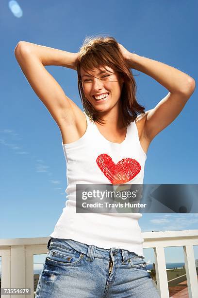 woman with her hands above her head - posing - hands in the air heart stock-fotos und bilder