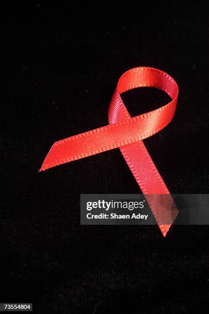 close-up of an aids ribbon against a black background - aids ribbon fotografías e imágenes de stock