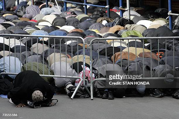 New York, UNITED STATES: Men pray outside the Islamic Cultural Center, 12 March 2007, in the Bronx borough of New York during a funeral for members...