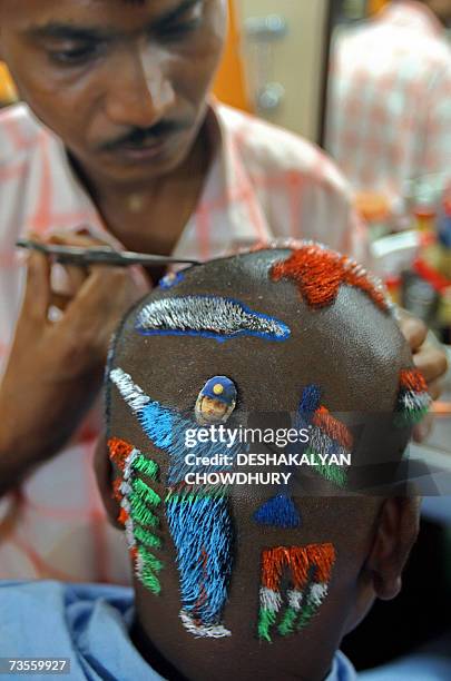 Indian hair dresser, Robin Das colours a 'Cricket World Cup' haircut at a hair salon in Howrah, near Kolkata, 13 March 2007. The eastern Indian city...