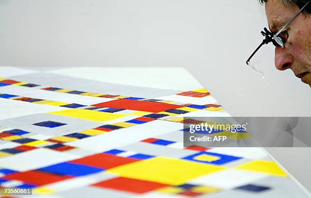 The Hague, NETHERLANDS: A researcher inspects a painting 'Victory Boogie Woogie' by Dutch Piet Mondrian 13 March 2007 at the Municipal Museum in The...