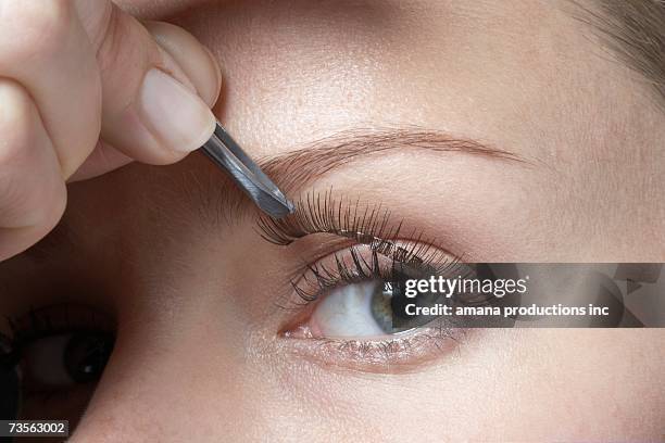 woman attaching fake eyelashes, close-up - positioned stock pictures, royalty-free photos & images