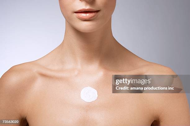 moisturizer on woman's chest - one young woman only photos et images de collection