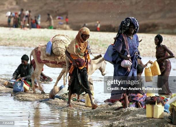 People supply up on water April 13, 2000 in a river close to Gode, in the Ogaden province of Ethiopia. Thousands of people, who have lost their...