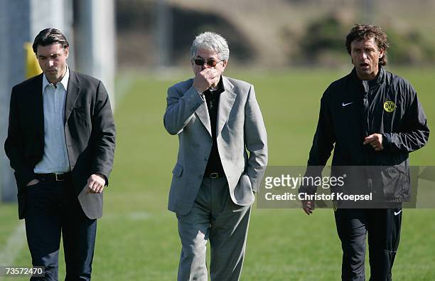 Team manager Michael Zorc, press officer Josef Schneck and head coach Thomas Doll look thoughtful during the Borussia Dortmund training session at...