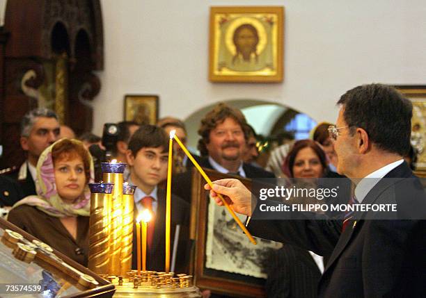 Italian Prime Minister Romano Prodi lights up a candle as he visits with Russian President Vladimir Putin the Basilica of San Nicola, a church that...