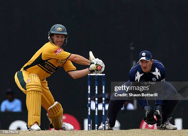 Brad Hogg of Australia plays a shot as Colin Smith the Scotland wicket-keeper looks on during the ICC Cricket World Cup 2007 Group A match between...