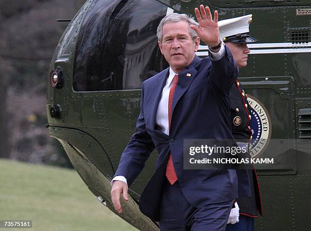 Washington, UNITED STATES: US President George W. Bush waves to wellwishers as he steps off Marine One on the South Lawn of the White House in...