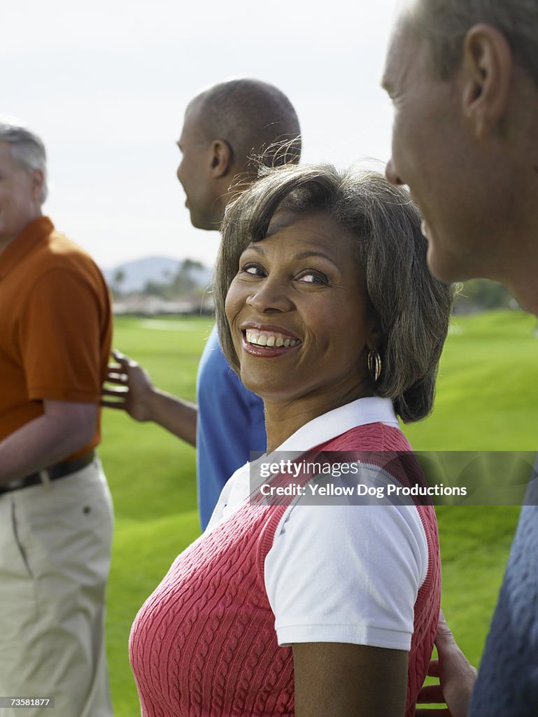 Black woman golfer talking with golf friends