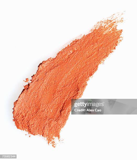 streak of orange eye shadow on white background - oogschaduw stockfoto's en -beelden