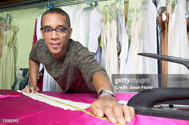 mature fashion designer measuring textile - jason florio stockfoto's en -beelden