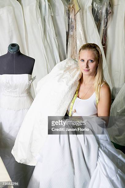 young fashion designer carrying wedding dress, portrait - jason florio stockfoto's en -beelden