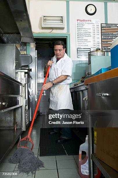 man mopping floor in commercial kitchen - jason florio stockfoto's en -beelden