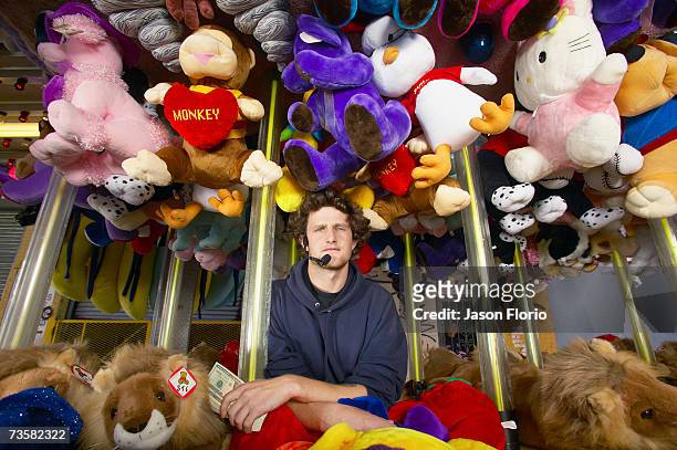 man surrounded by soft toys in stall, portrait - jason florio stockfoto's en -beelden