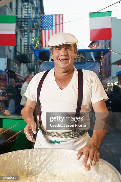 mature man preparing dough on food stall, portrait - jason florio stockfoto's en -beelden