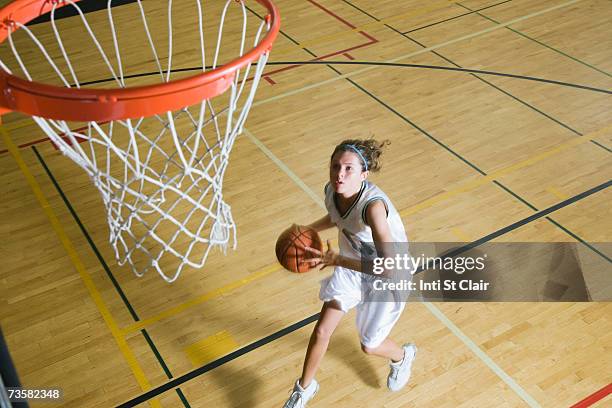 teenage girl (16-18) playing basketball, elevated view - teenage girl basketball photos et images de collection