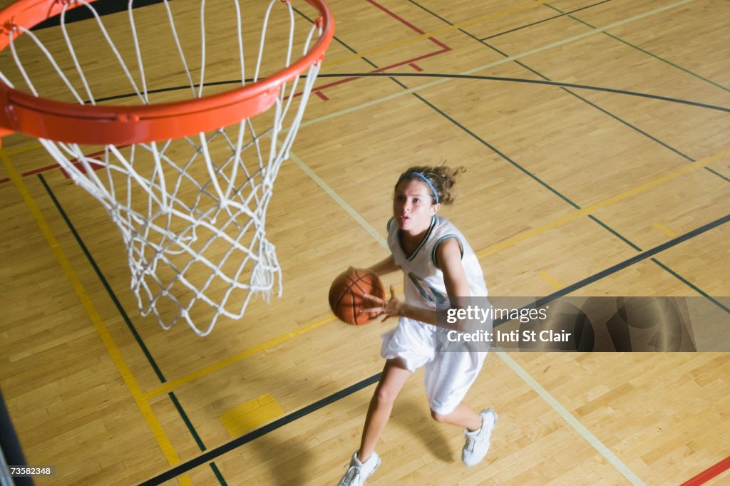 Teenage girl (16-18) playing basketball, elevated view