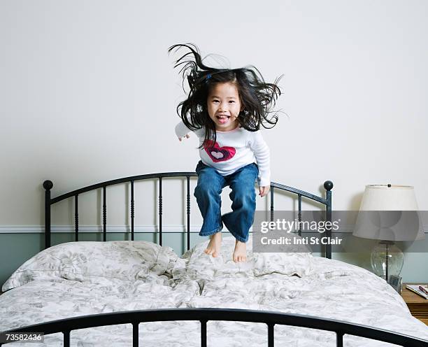 girl (3-5) jumping on bed - children jumping bed stock pictures, royalty-free photos & images