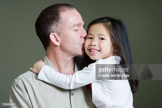father kissing adopted chinese daughter's cheek (3-5) - adopted chinese daughter stock pictures, royalty-free photos & images