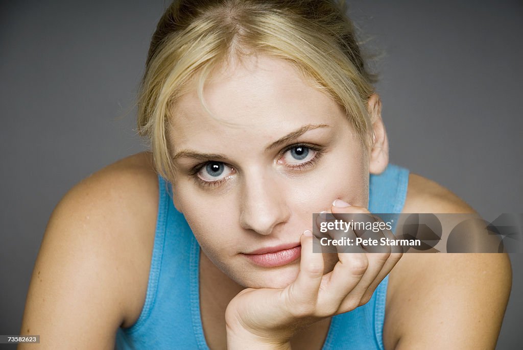 Young woman with hand on chin, portrait