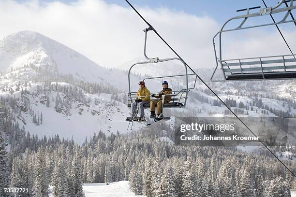 usa, utah, teenage girl and boy (13-16) sitting on ski lift at brighton ski resort - vacaciones en la nieve fotografías e imágenes de stock