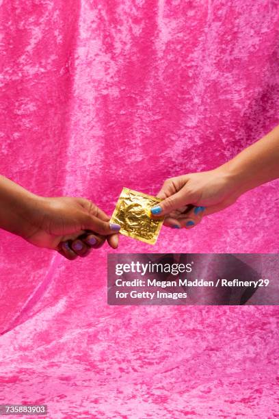 two young women holding condom - johnny stock pictures, royalty-free photos & images