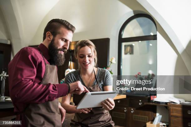 owners discussing using tablet at restaurant - newtechnology stock pictures, royalty-free photos & images