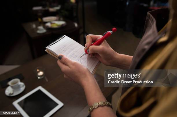 cropped image of woman taking order while espresso and tablet kept on dining table at restaurant - newtechnology stock pictures, royalty-free photos & images
