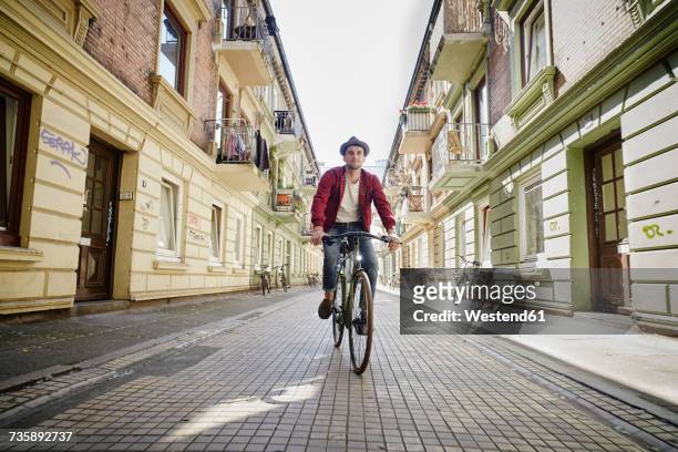 germany, hamburg, st. pauli, man riding bicycle in he city - hamburg stock pictures, royalty-free photos & images