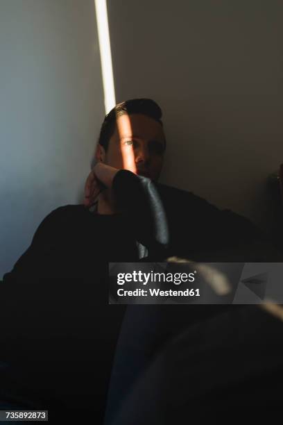 man hiding in the shadow of his room at home - nascondere foto e immagini stock