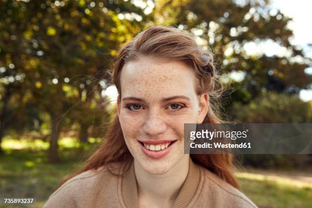 portrait of smiling redheaded young woman with freckles - freckle stock pictures, royalty-free photos & images