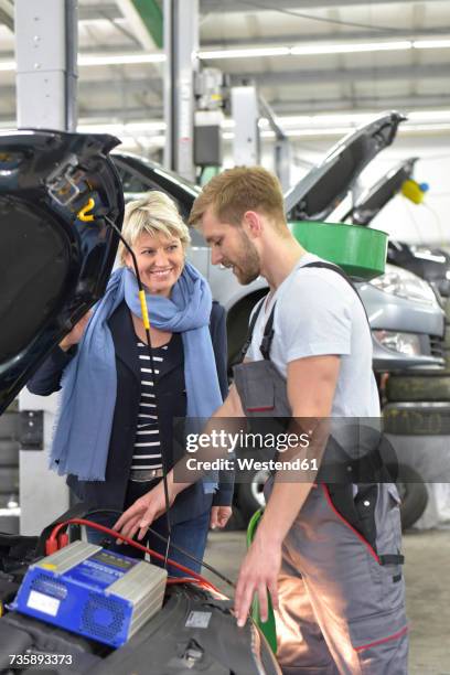 car mechanic with client in workshop at car - guaranteed power supply stock pictures, royalty-free photos & images